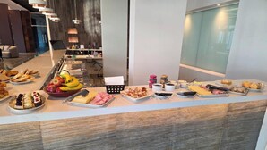 Un bufé con diversos alimentos y utensilios.