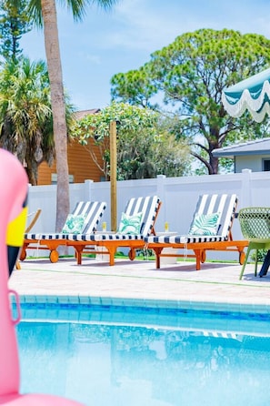 A swimming pool with lounge chairs and a palm tree. - Pool, Hot Tub, PickleBall, Firepit, 5 min to IMG (Bradenton)