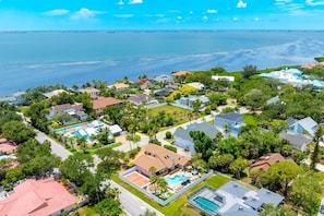 A residential area with houses, a swimming pool, and a view of the ocean. - Pool, Hot Tub, PickleBall, Firepit, 5 min to IMG (Bradenton)