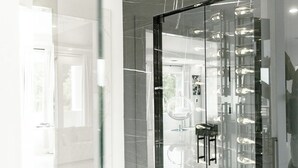 Un interior moderno con un separador de vidrio, una zona de estar circular y una exhibición de zapatos a la vista.