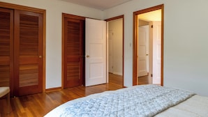 Ein Schlafzimmer mit einem Bett, Holztüren und einem Flur.