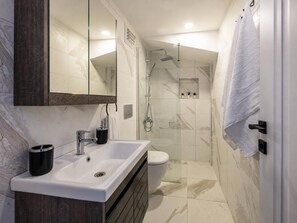 A bathroom with a white sink, a toilet, a shower, and a mirror above the sink. - Huge Balcony Taksim Rooftop Apt At Monnas Suite (Istanbul)