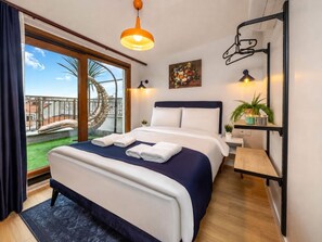 A hotel room with a bed, a view of a balcony, a painting, and a wall-mounted shelf with plants. - Huge Balcony Taksim Rooftop Apt At Monnas Suite (Istanbul)