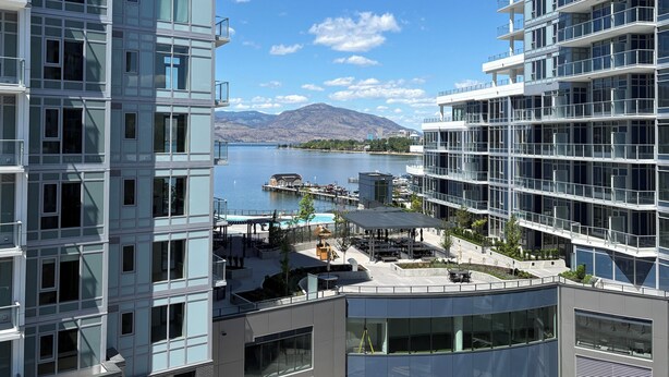A modern hotel with a view of a lake and mountains. - Premiere Lakeshore Living with excellent amenities. Dog friendly (Kelowna)