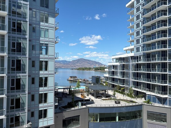 A modern hotel with a view of a lake and mountains.