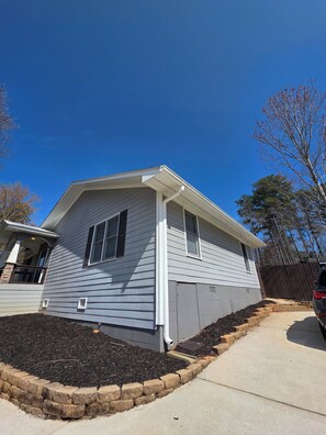 A residential house with a sloped roof, a front porch, and a driveway. - Lake Lanier Getaway. Hot Tub & Fire Pit. 5-Min Walk to Lake Access (Flowery Branch)