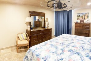 Ein Schlafzimmer mit Bett, Schminktisch, Stuhl und Spiegel.