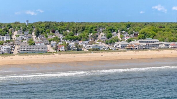 A coastal town with beachfront properties, a sandy beach, and a view of the ocean.