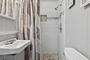 Ein Badezimmer mit Dusche, Waschbecken und Toilette.