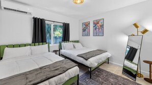 Een hotelkamer met twee bedden, een grote spiegel en kunst aan de muur.