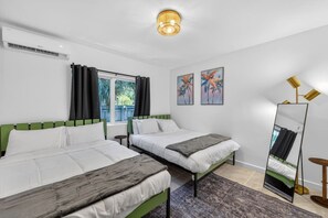 Ein Hotelzimmer mit zwei Betten, einem großen Spiegel und Bildern an der Wand.