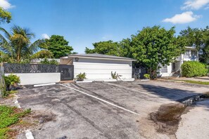 Ein Wohnhaus mit Garage, geschlossenem Eingangstor und Auffahrt.