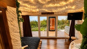 A room with a bed, a bathtub, and a TV. There is a sign that reads 'Montebliss 4'. - Cozy Chalet with Jacuzzi, Heated pool & Sauna Montebliss (Miljevići)