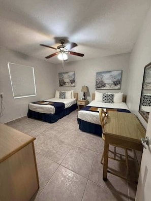 A bedroom with two beds, a ceiling fan, a desk, and a chair. - Oceanview Retreat in Hollywood Beach (Hollywood)