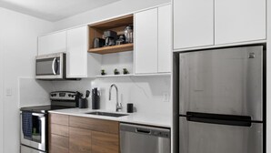 Eine moderne Küche mit Edelstahlgeräten, Holzschränken und einer eingebauten Mikrowellenregal.