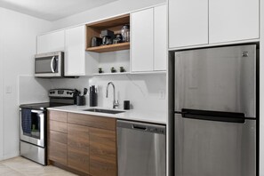 Eine moderne Küche mit Edelstahlgeräten, Holzschränken und einer eingebauten Mikrowellenregal.