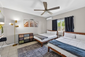 A bedroom with two beds, a ceiling fan, a bedside table, a lamp, a dresser, and artwork on the wall. - 15 min to Beach | 2 Queen Beds | Free Parking (U4) (Miami)