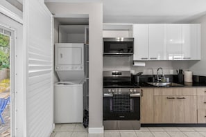 A compact kitchen with a washing machine, a stove, a microwave, and a sink. - 15 min to Beach | 2 Queen Beds | Free Parking (U4) (Miami)