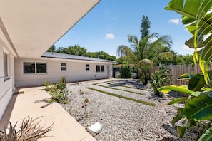 A residential property with a covered patio, a gravel driveway, and a variety of tropical plants. - 15 min to Beach | 2 Queen Beds | Free Parking (U4) (Miami)