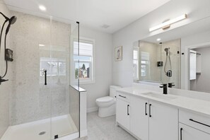 A modern bathroom with a glass-enclosed shower, a white toilet, and a large mirror. - Beautiful 3BR Getaway in Trendy NW Calgary (Calgary)