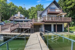 A house with a dock, a boat, and a small water body. - Sleep 22, private pool, pickleball ct, hot tub (Sunrise Beach)