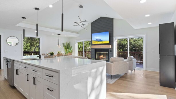 A modern kitchen with a large island, built-in appliances, and a fireplace.