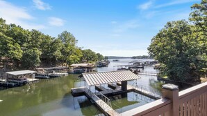 A marina with docked boats, a covered boat launch, and a wooden deck overlooking the water.