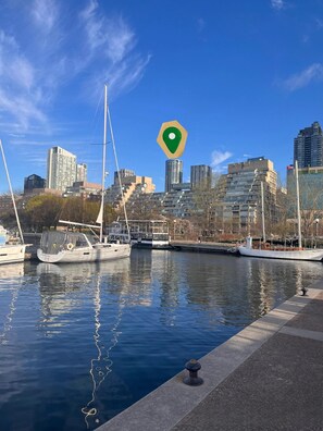 A marina with boats docked, a city skyline in the background, and a clear blue sky. - FIFA unobstructive view CN TOWER lakeshore 1+1(den) 2b1b condo with parking (Toronto)