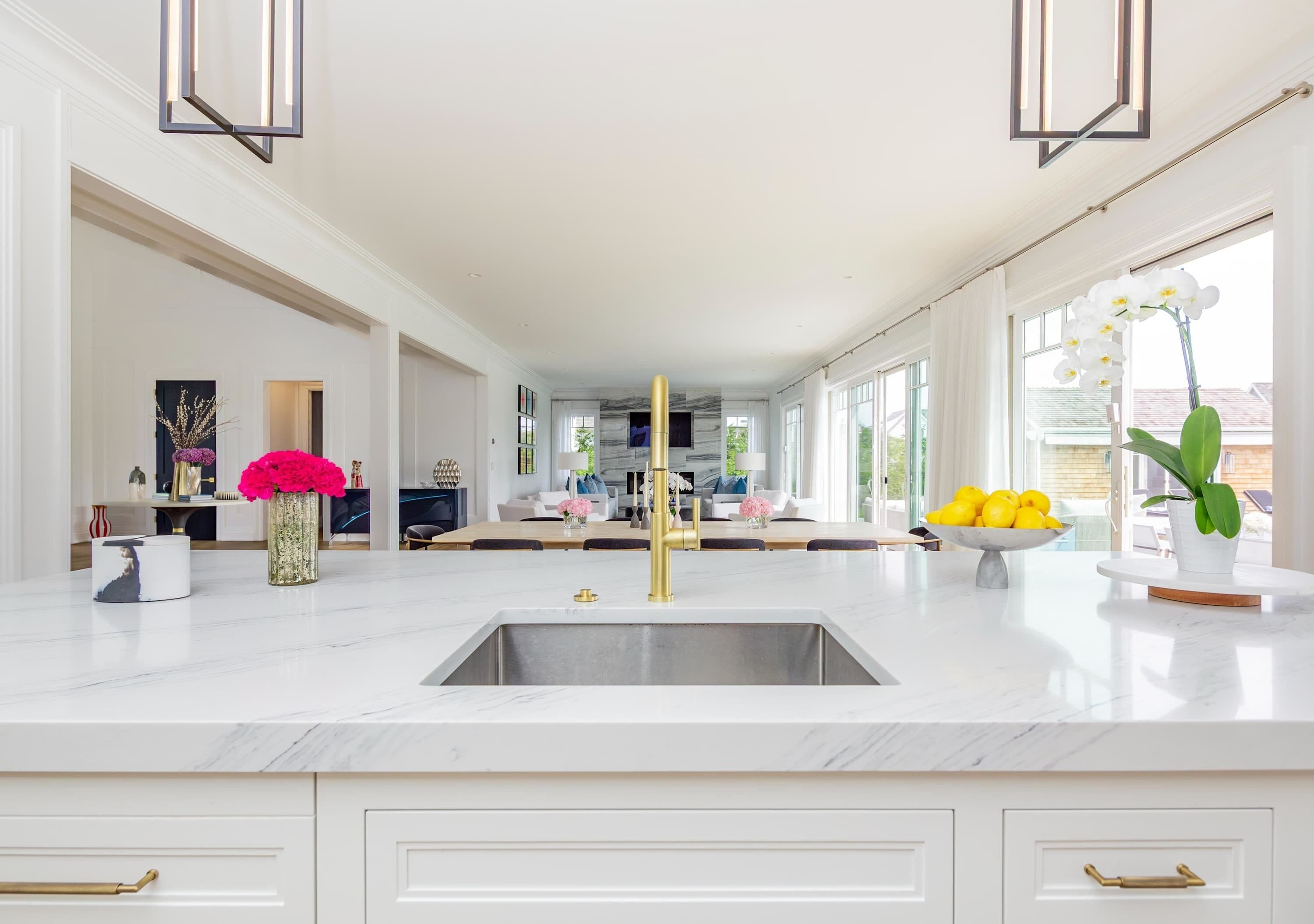 A modern kitchen with a central island, a large window, and a view of the outdoors.