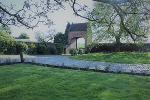A brick archway, a paved pathway, and a grassy area. - Renovated house in an old farmhouse 12km from the center of Brussels (Sint-Pieters-Leeuw)