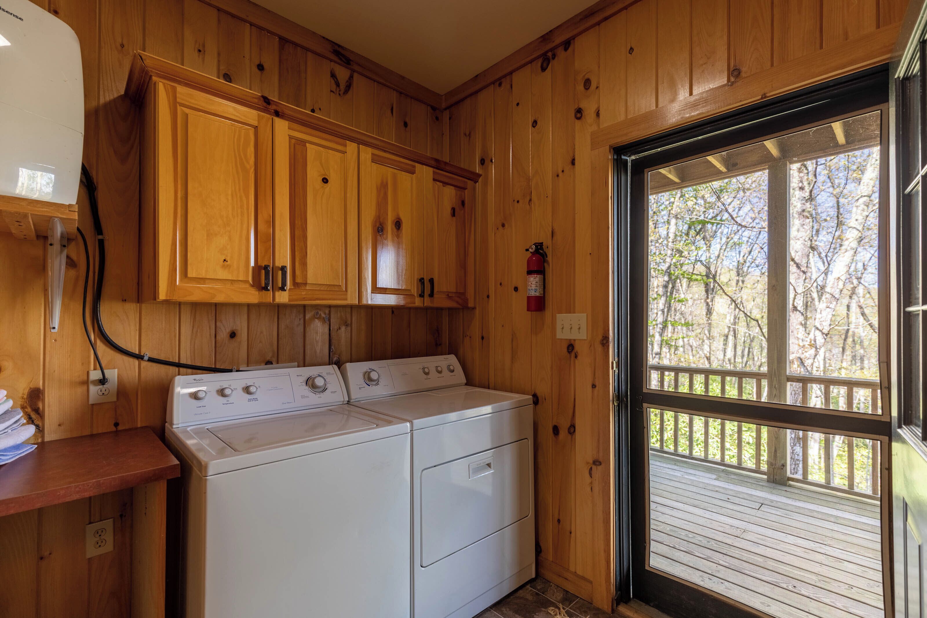 A laundry room with wooden cabinets and a washer and dryer.