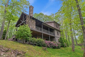 A two-story log cabin with a balcony, surrounded by a forest. - Sweet Retreat at Sweetgrass (Blowing Rock)