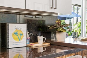 A modern kitchen with a sign for Serenity Place, a potted plant, and a coffee mug on the counter.