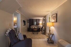 Ein gemütliches Wohnzimmer mit einer Couch, einem Couchtisch und einer Lampe.