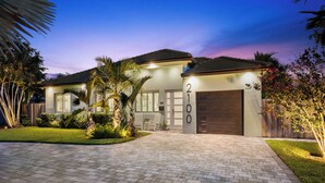 A modern two-story house with a paved driveway, a garage, and a well-maintained lawn. - Bahama Breeze (Oakland Park)