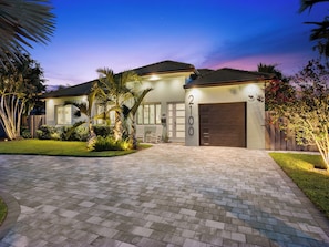 A modern two-story house with a paved driveway, a garage, and a well-maintained lawn. - Bahama Breeze (Oakland Park)