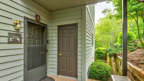 A house with two doors, a welcome sign, and a porch with a bench.