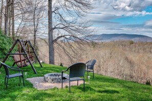 A patio with a swing set, two chairs, and a fire pit. - Hilltop Hideaway (Boone)