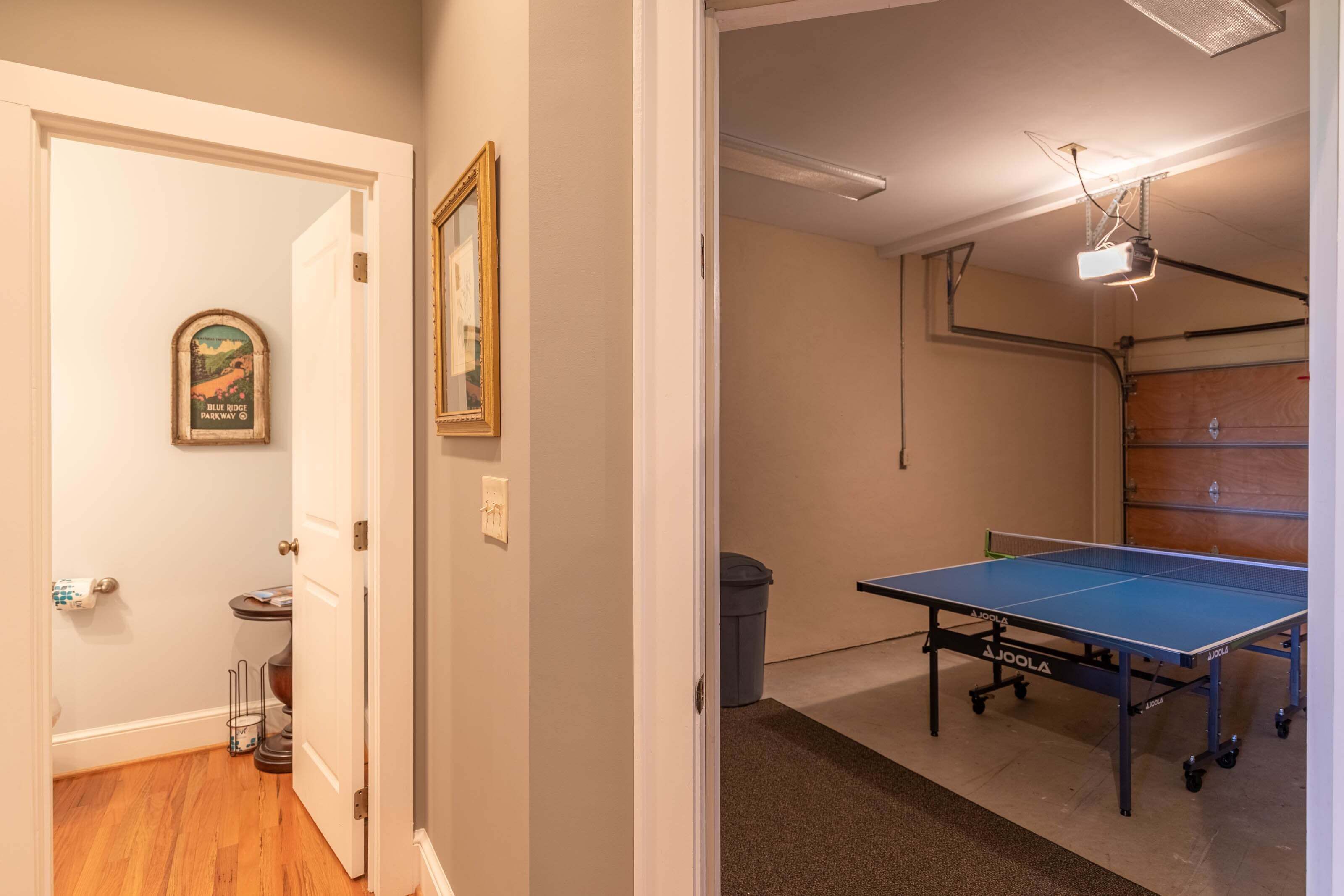 A room with a ping pong table, a projector, and a door leading to another room.