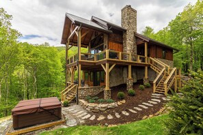 Eine Blockhütte mit einem Steinkamin, einer Holzdiele und einer Steintreppe, die zu der oberen Ebene führt.