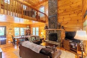 A log cabin interior with a dining area, living room, fireplace, and a balcony. - 1 Sweet Seclusion Peaceful Cabin Just Outside of Boone With hot tub (Vilas)