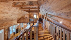 A wooden interior with a staircase leading to a loft area, featuring a dining table and chairs. - Hidden Serenity Hot Tub, Fire Pit, Minutes From Boone (Fleetwood)