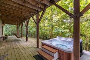 A wooden deck with a hot tub, wooden benches, and a covered area. - 1 Abundant Life (Vilas)