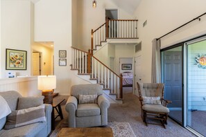 A living room with a staircase, two armchairs, a lamp, and a chair with a cushion. - Chetola Chestnut 8 (Blowing Rock)