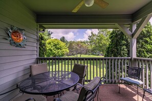 A covered patio with a round table and chairs, a bench, and a decorative wall piece. - Chetola Chestnut 8 (Blowing Rock)