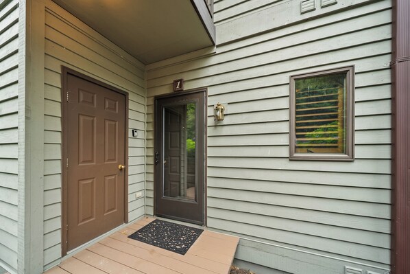 A house with a brown front door, a small window with a view, and a doormat. - Chetola Sierra 1 (Blowing Rock)