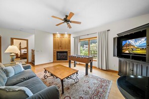 A living room with a foosball table, a sofa, a coffee table, a fireplace, and a television. - Chetola Sierra 1 (Blowing Rock)