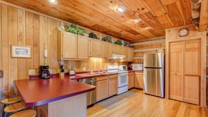 Eine Küche mit Holzausstattung, einem Edelstahlkühlschrank und einer Arbeitsplatte aus Holz.