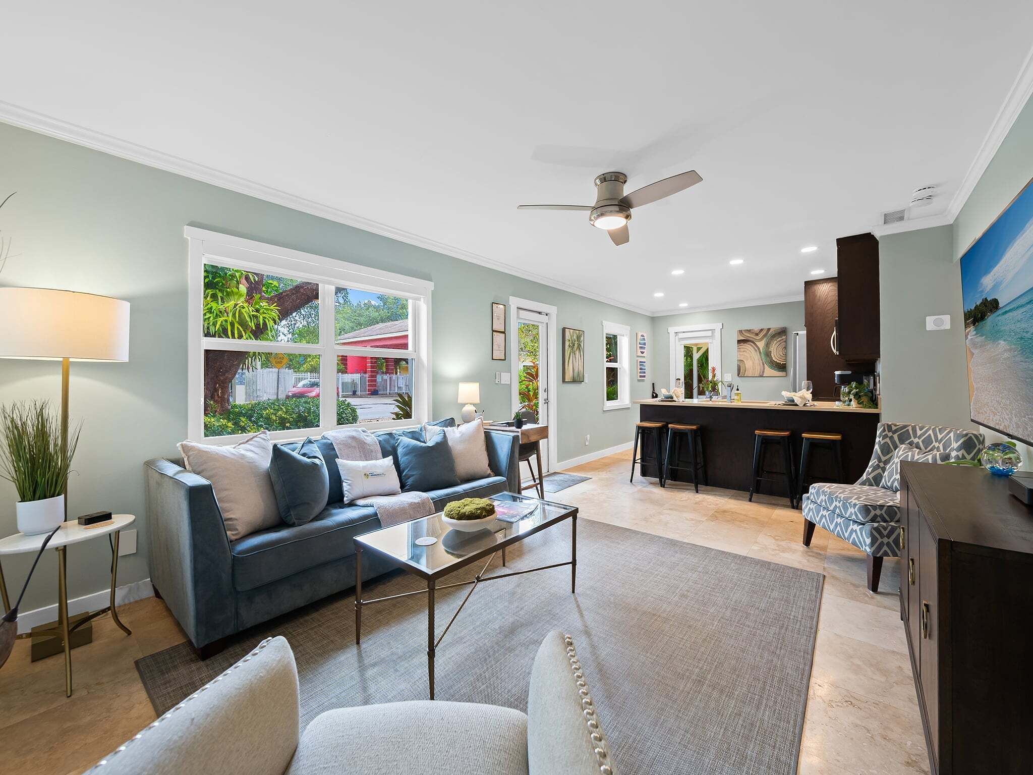 A modern living room with a sofa, coffee table, and a view of the outside.