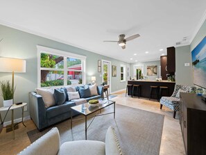 Ein modernes Wohnzimmer mit einer Couch, einem Couchtisch und Blick ins Freie.